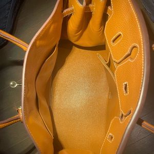 Short, double handle handbag. Tan color. Comes with lock and key. Like new.